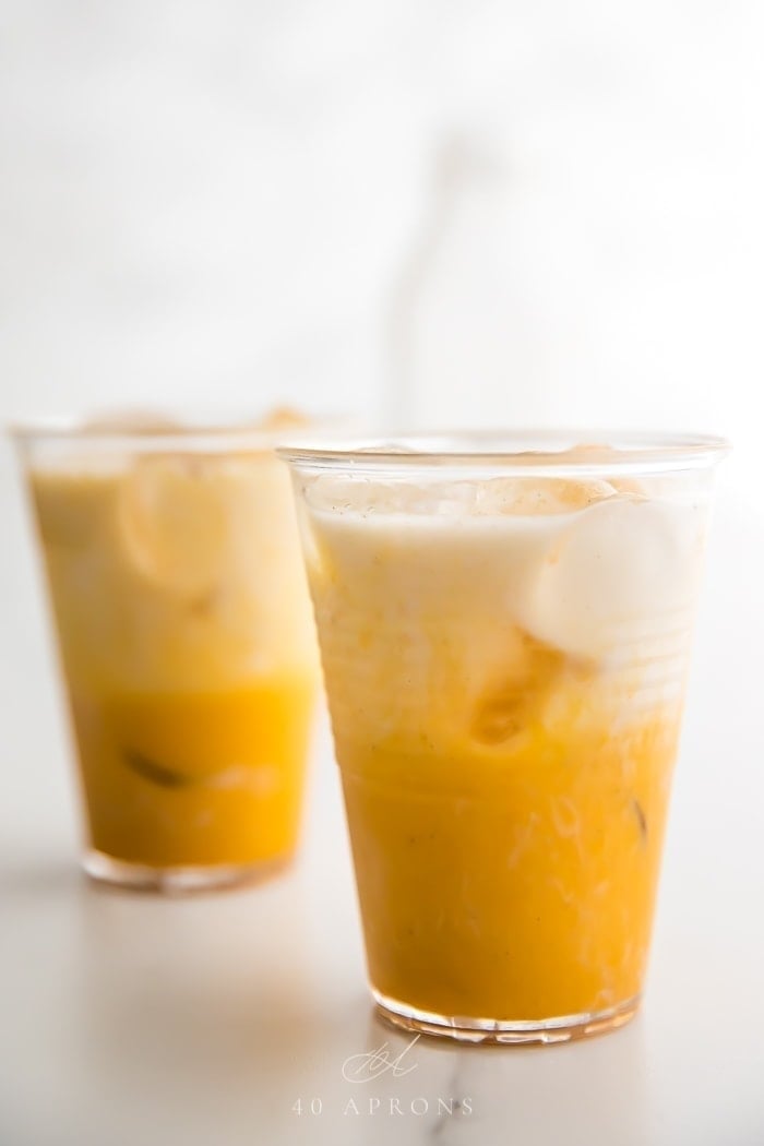 Two iced golden milks on a marble surface