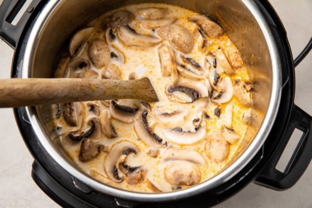 Instant Pot tom kha soup in Instant Pot with wooden spoon