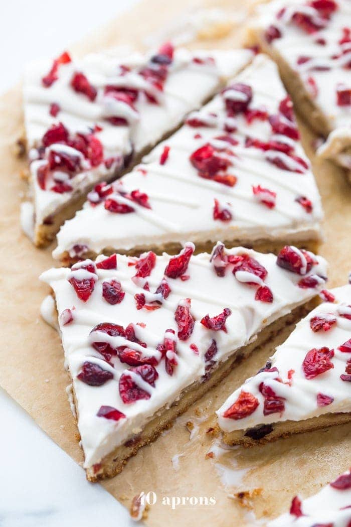These paleo cranberry bliss bars are just that: bliss! These vegan cranberry bliss bars are a grain-, gluten-, and dairy-free paleo Starbucks copycat recipe that's perfect for the holidays. Blondies, layered with "cream cheese" frosting, topped with dried cranberries, these paleo cranberry bliss bars are so delicious. You'll love these vegan cranberry bliss bars because they're a holiday treat that are totally guilt-free!